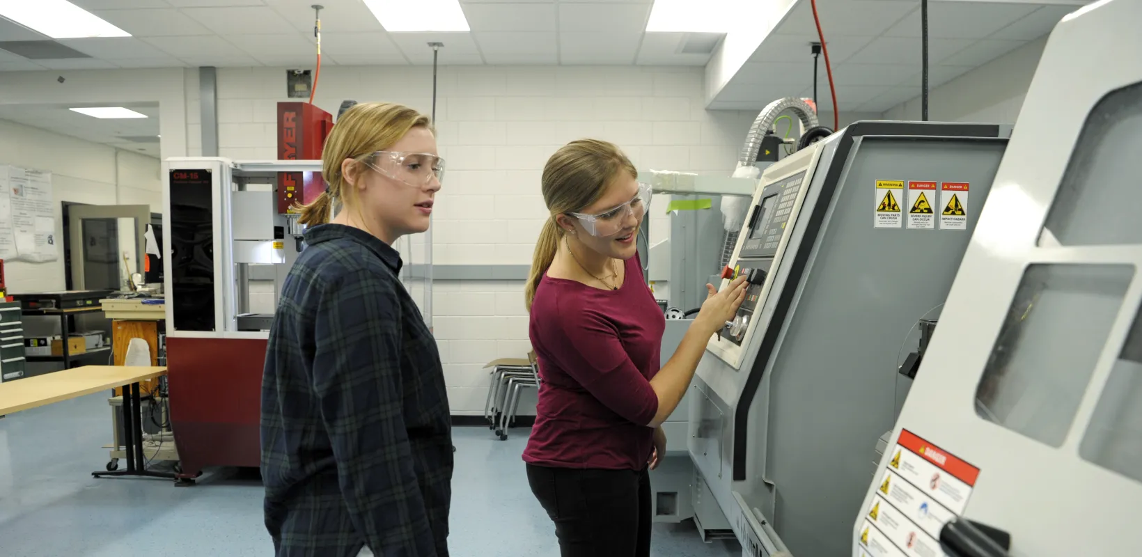two female students work in lab on testing equipment