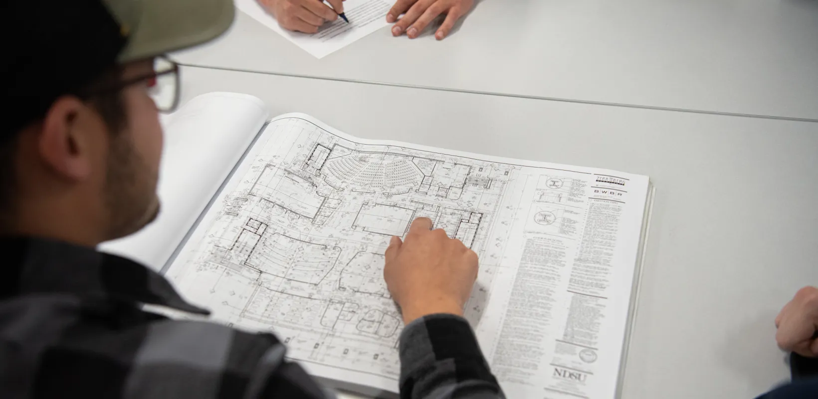 students studying construction plans during a construction management class