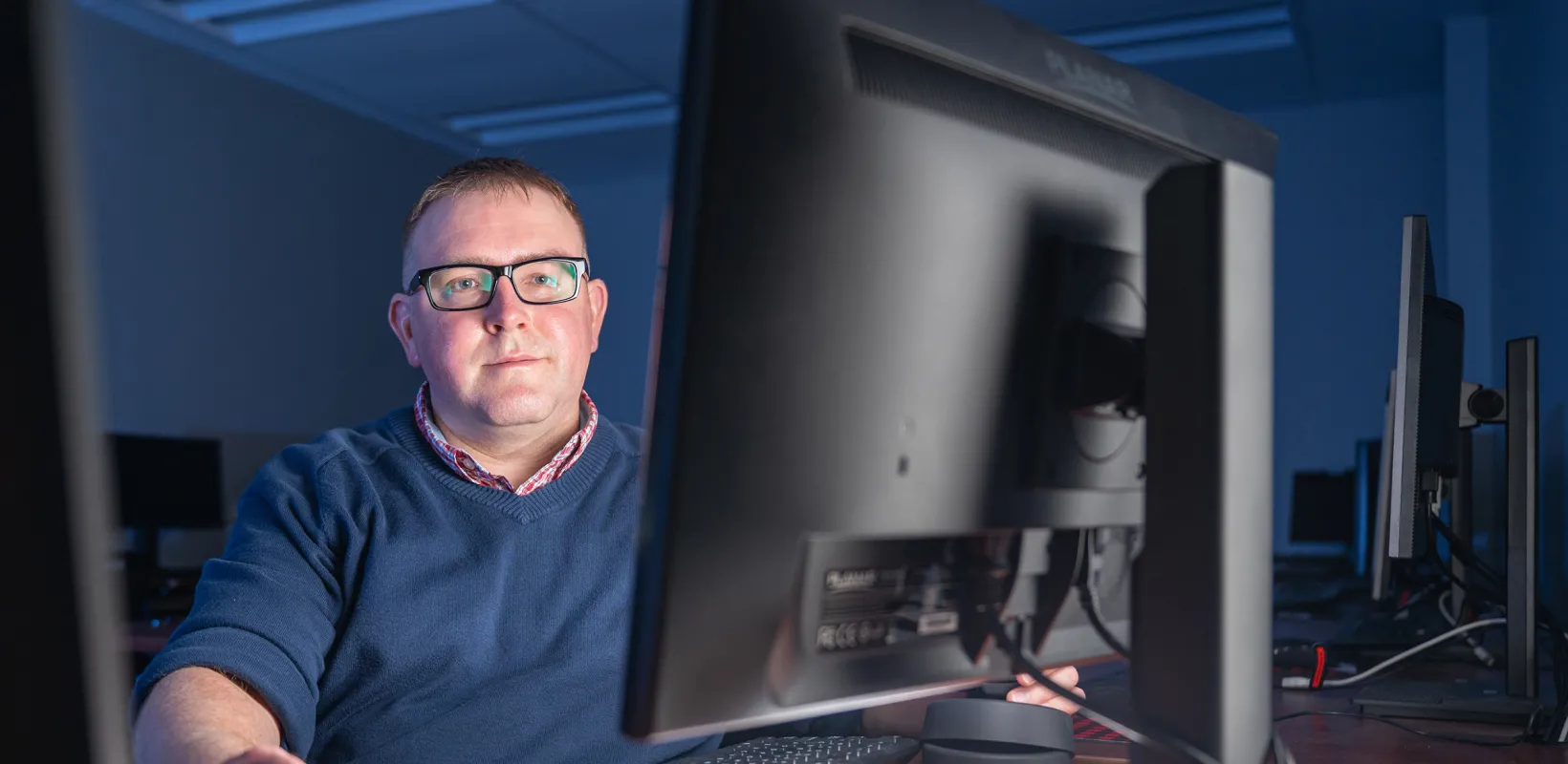 student looking at a computer monitor in a computer lab