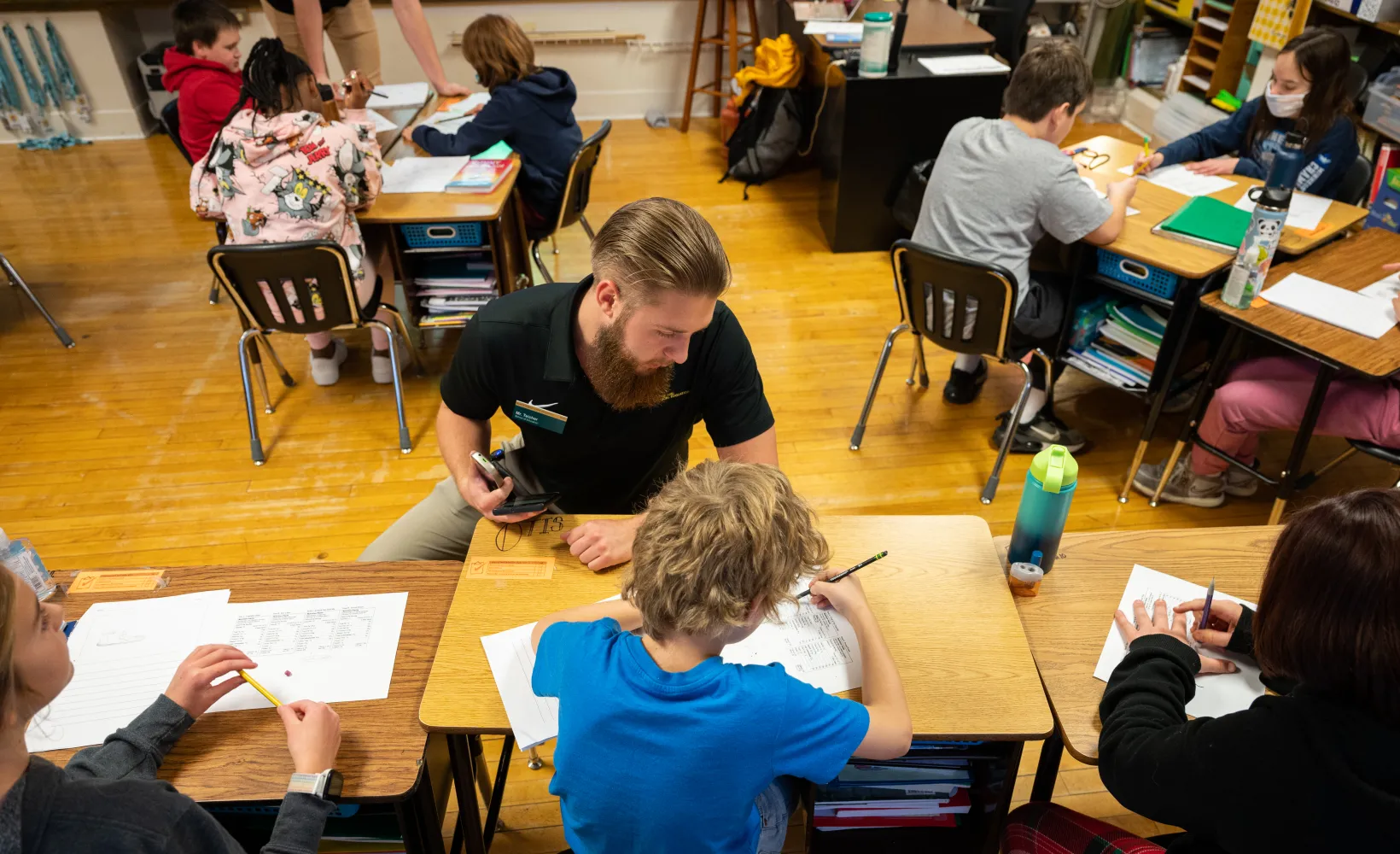 Student teacher working with student at students desk
