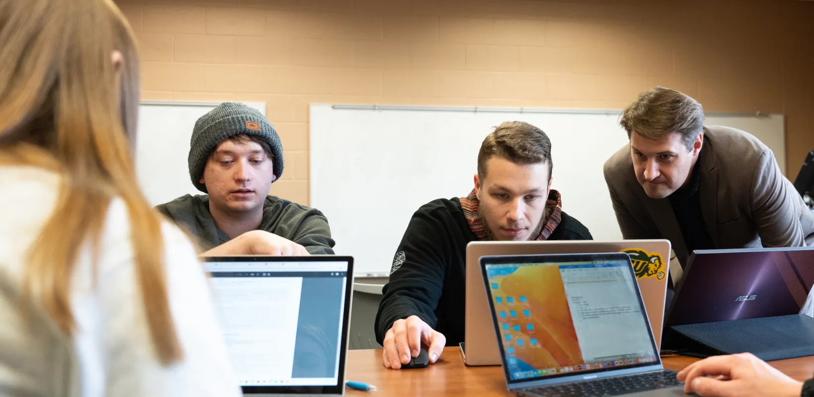 students and faculty looking at computer during accounting class
