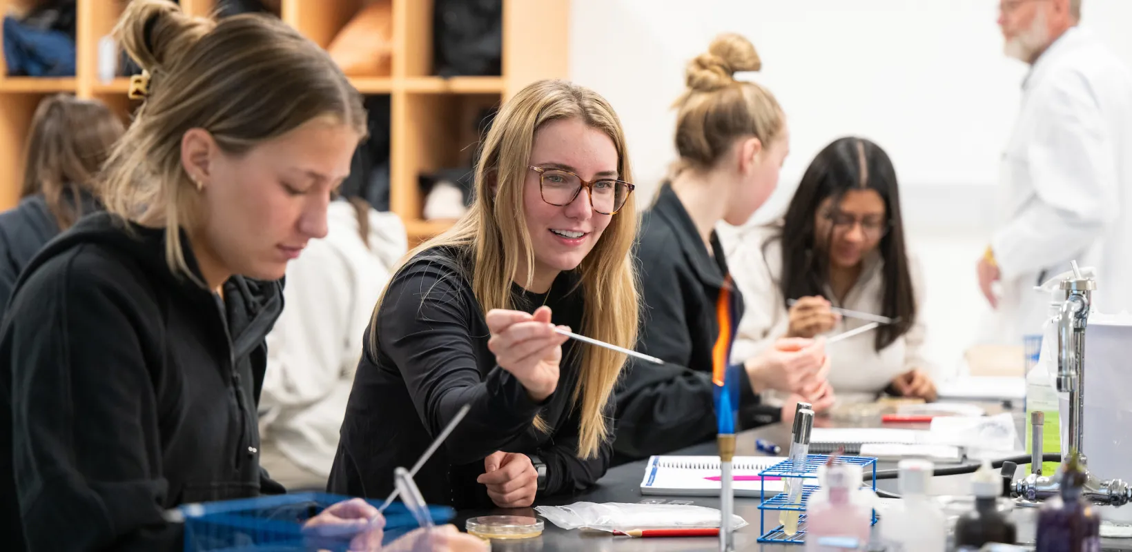Student working with a bunsen burner in a lab. 