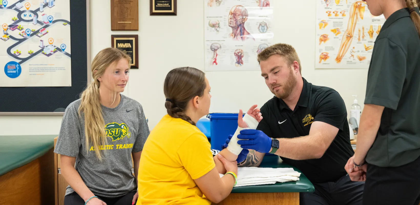 students practicing athletic training techniques on each other