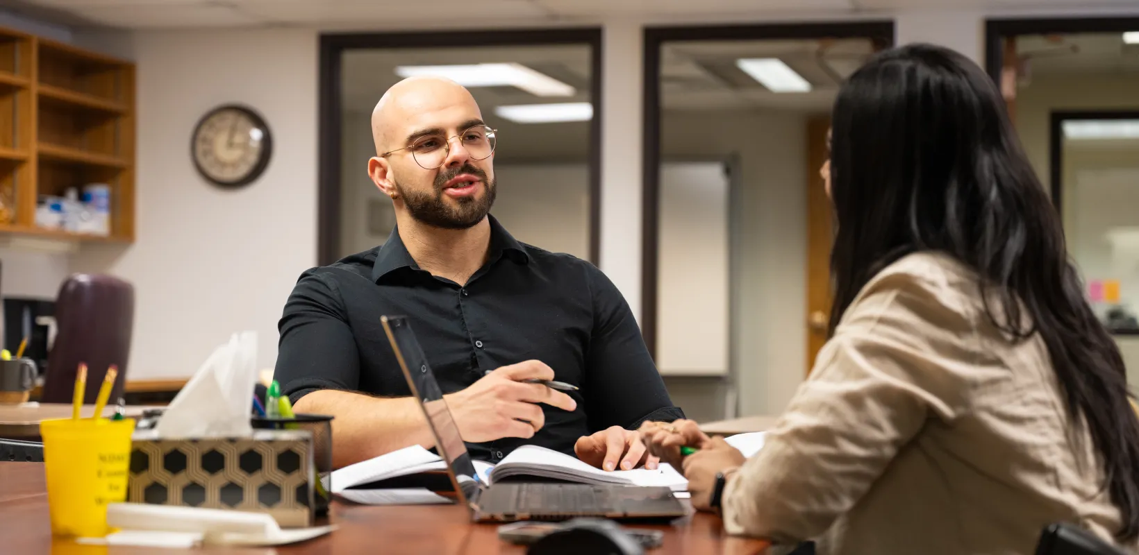 Two graduate students working together at a table.