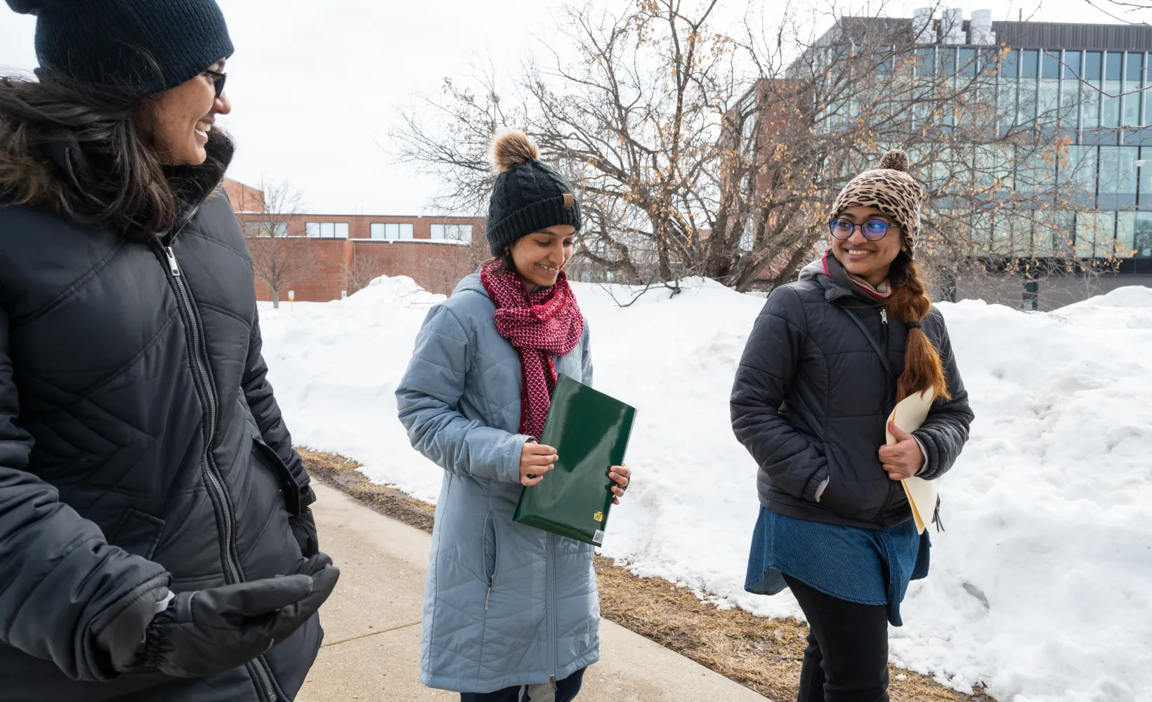 3 international students walking side by side in the snow