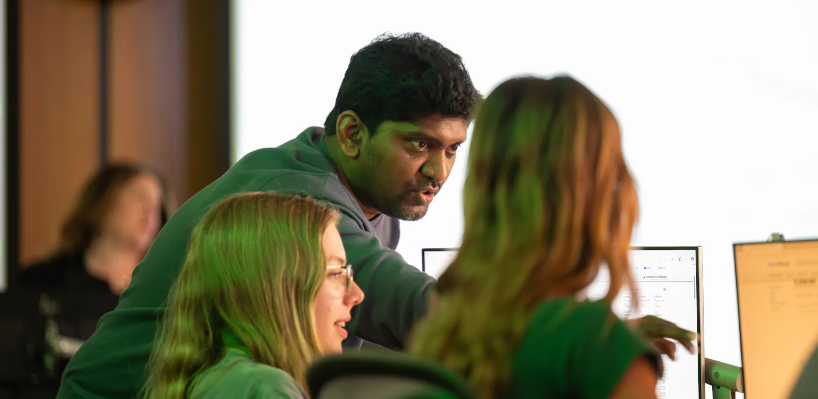 faculty and students having discussion while looking at a computer screen