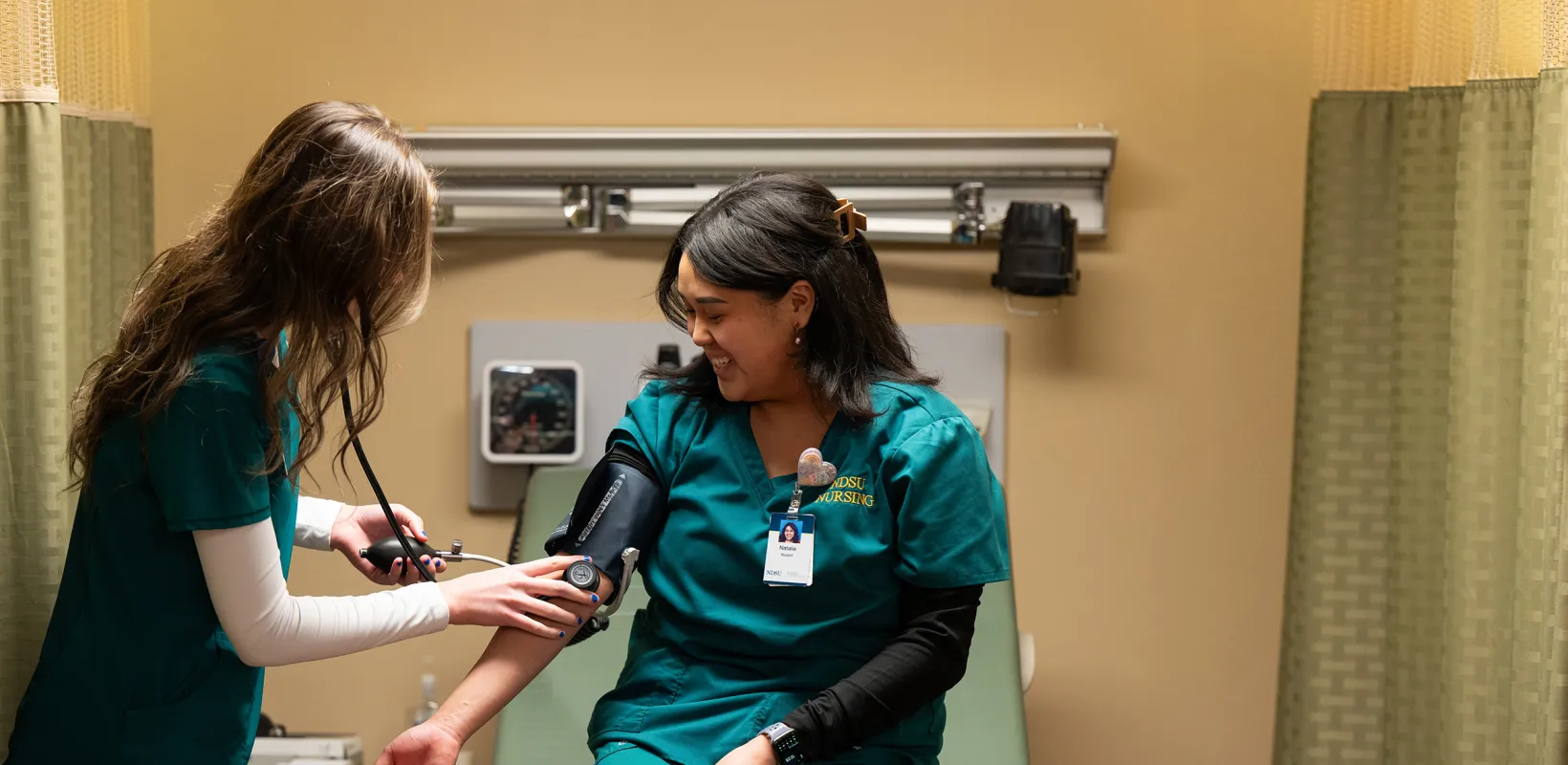 nursing students practicing with the blood pressure cuff