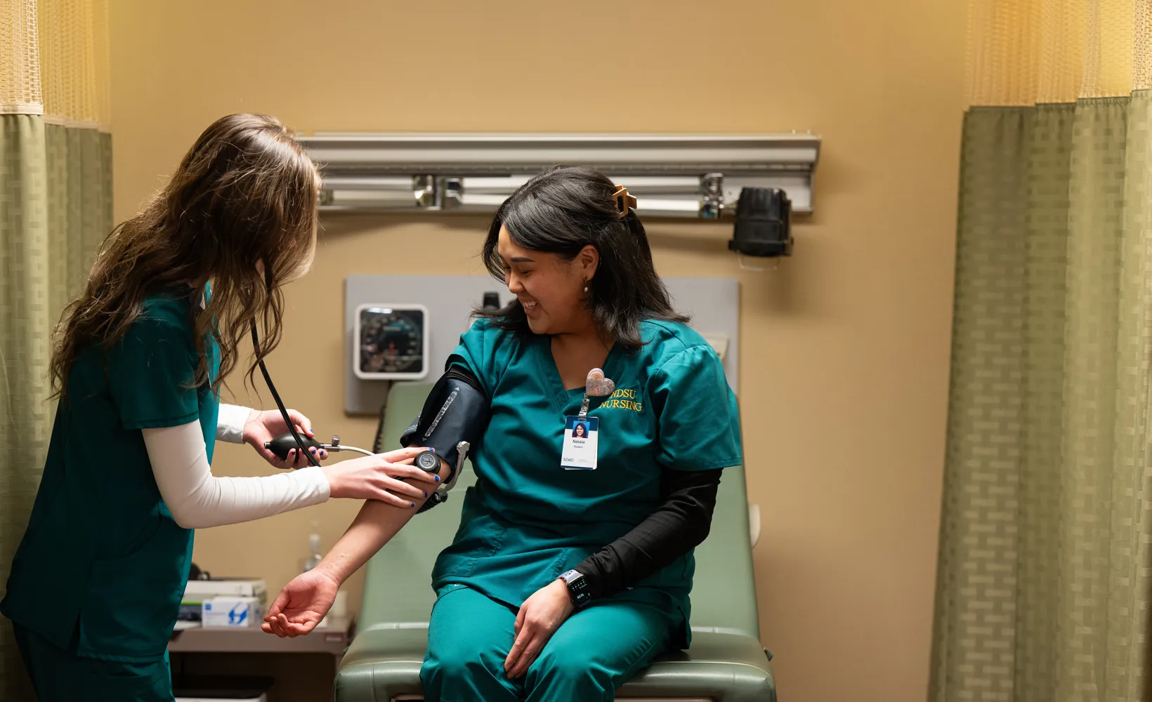 nursing students practicing with the blood pressure cuff