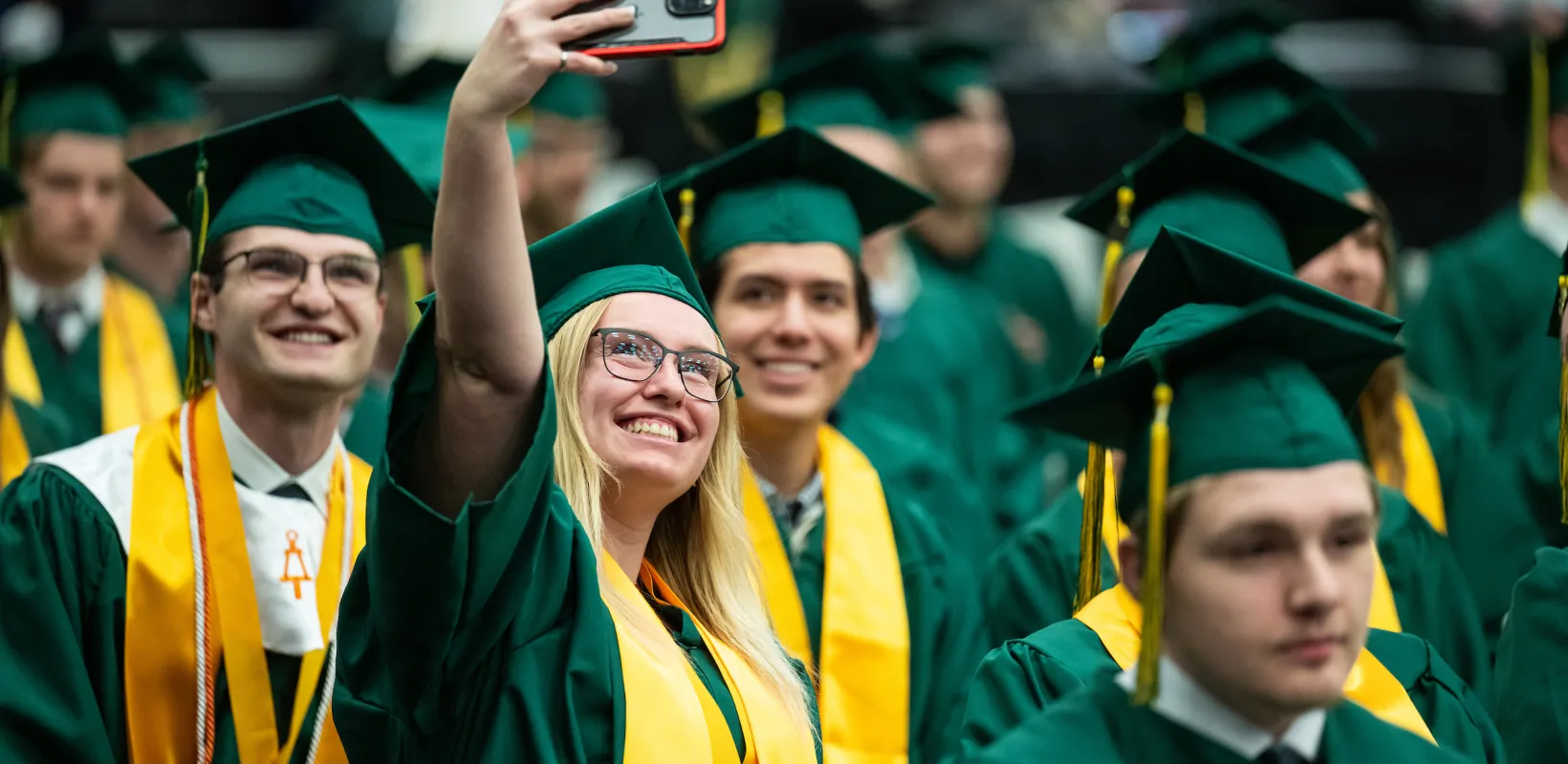 NDSU graduates taking group selfies at commencement celebration