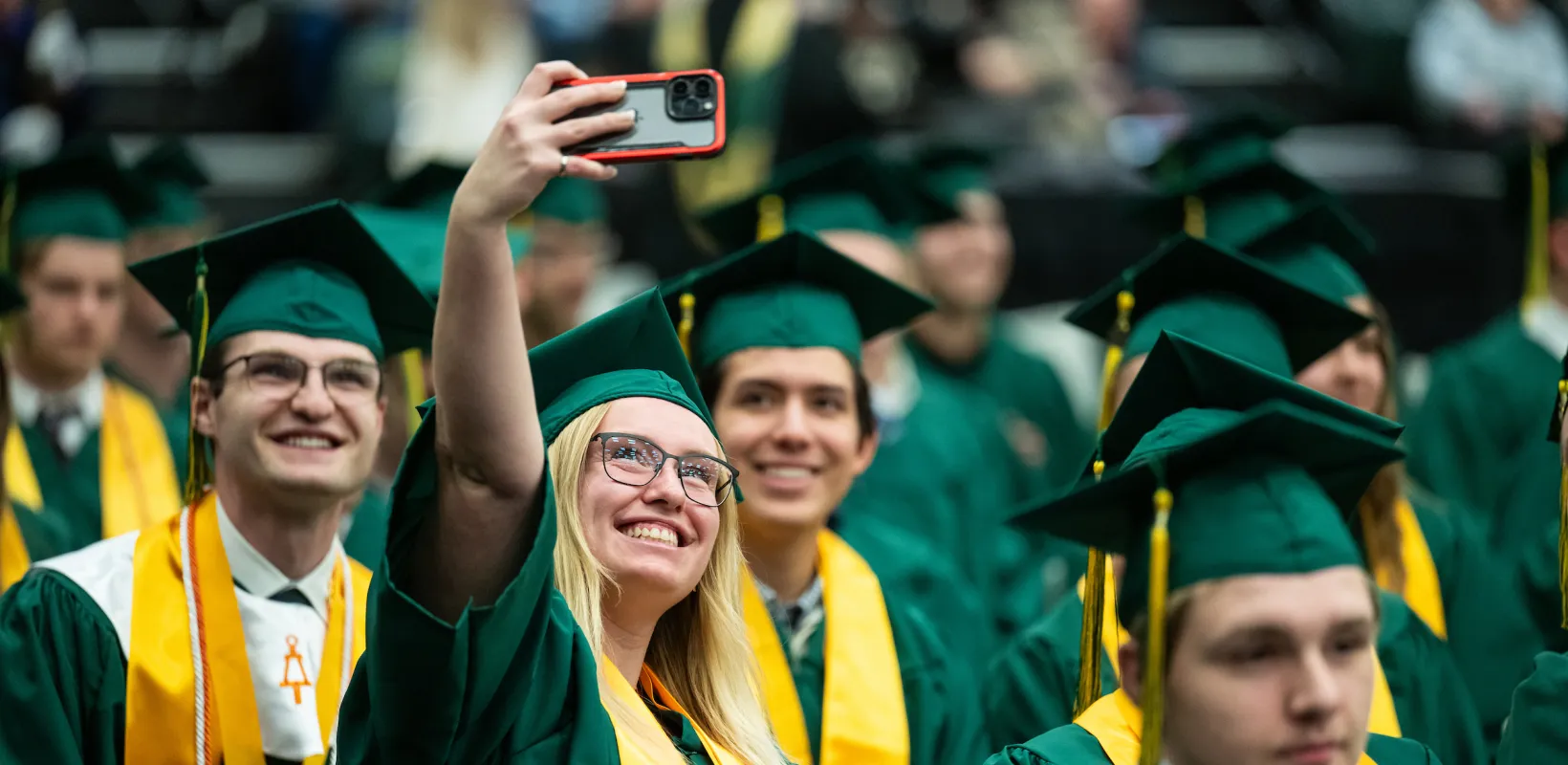 NDSU graduates taking group selfies at commencement celebration