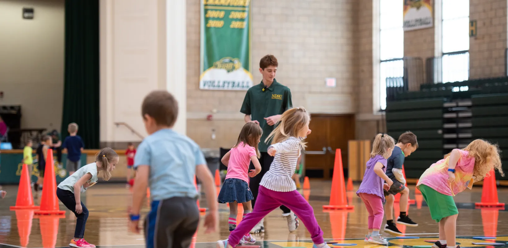 Students participating in a gym class with a student teacher.