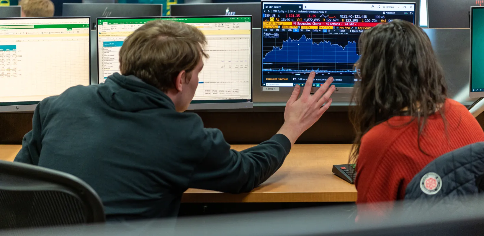 Students looking at computer in commodity trading room
