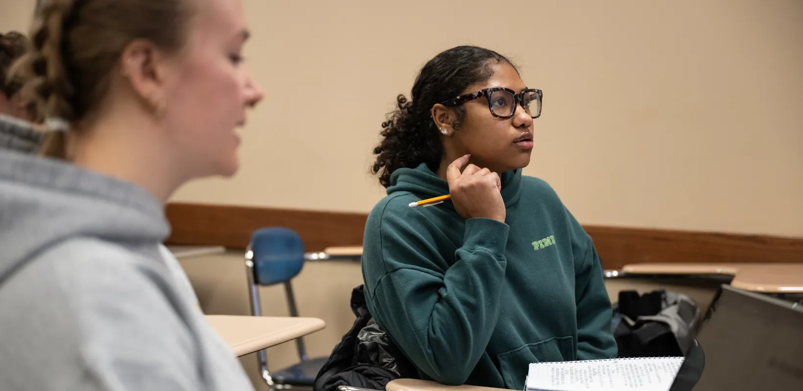 Student sitting in classroom working with pencil and paper.