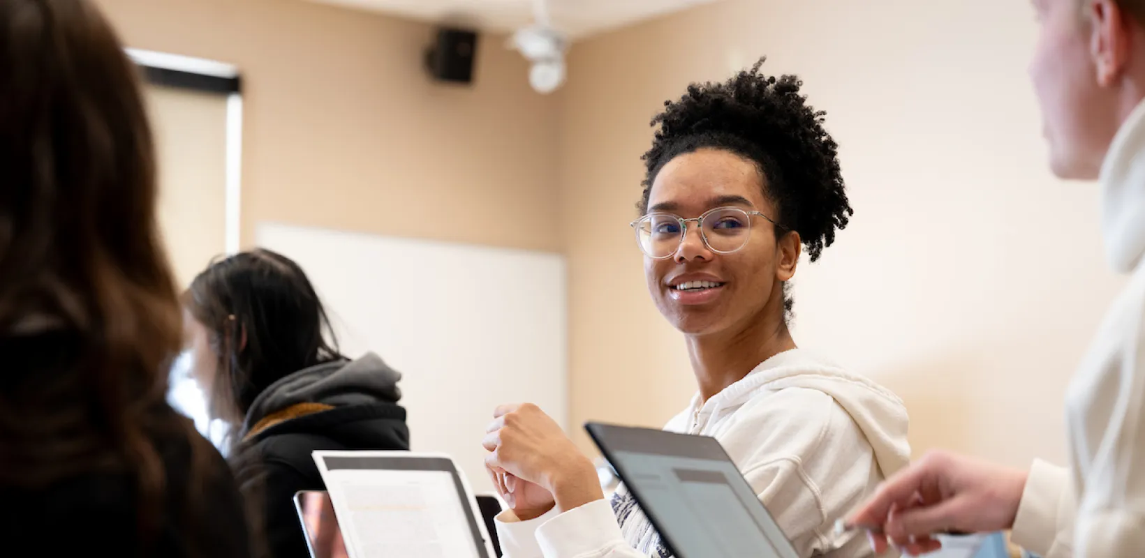 Student sitting at desk turned while looking at student behind.