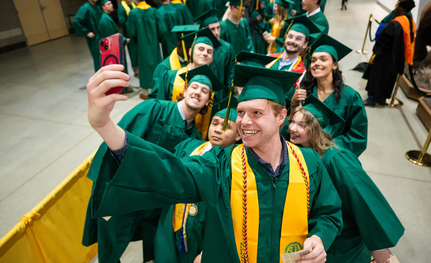 group of graduates gather for a selfie at commencement