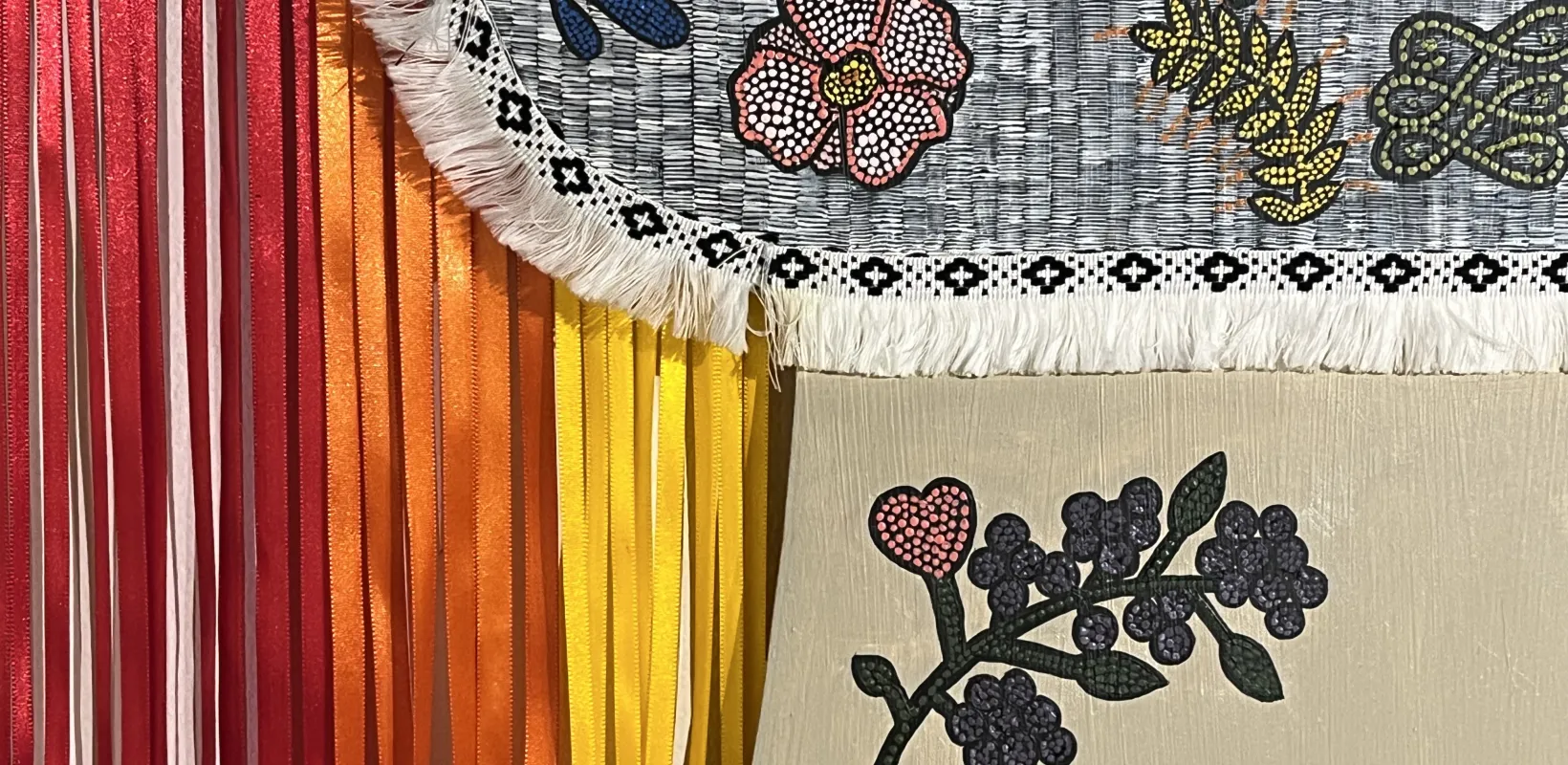 Detail of an indigeninous painting featuring plants and ribbons