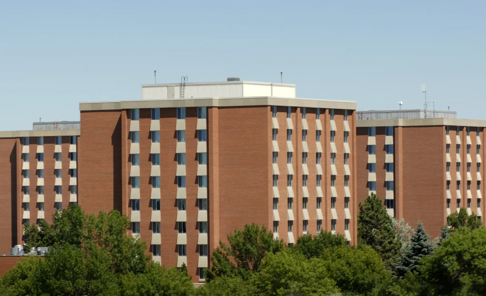 drone shot of three high rise brick housing buildings