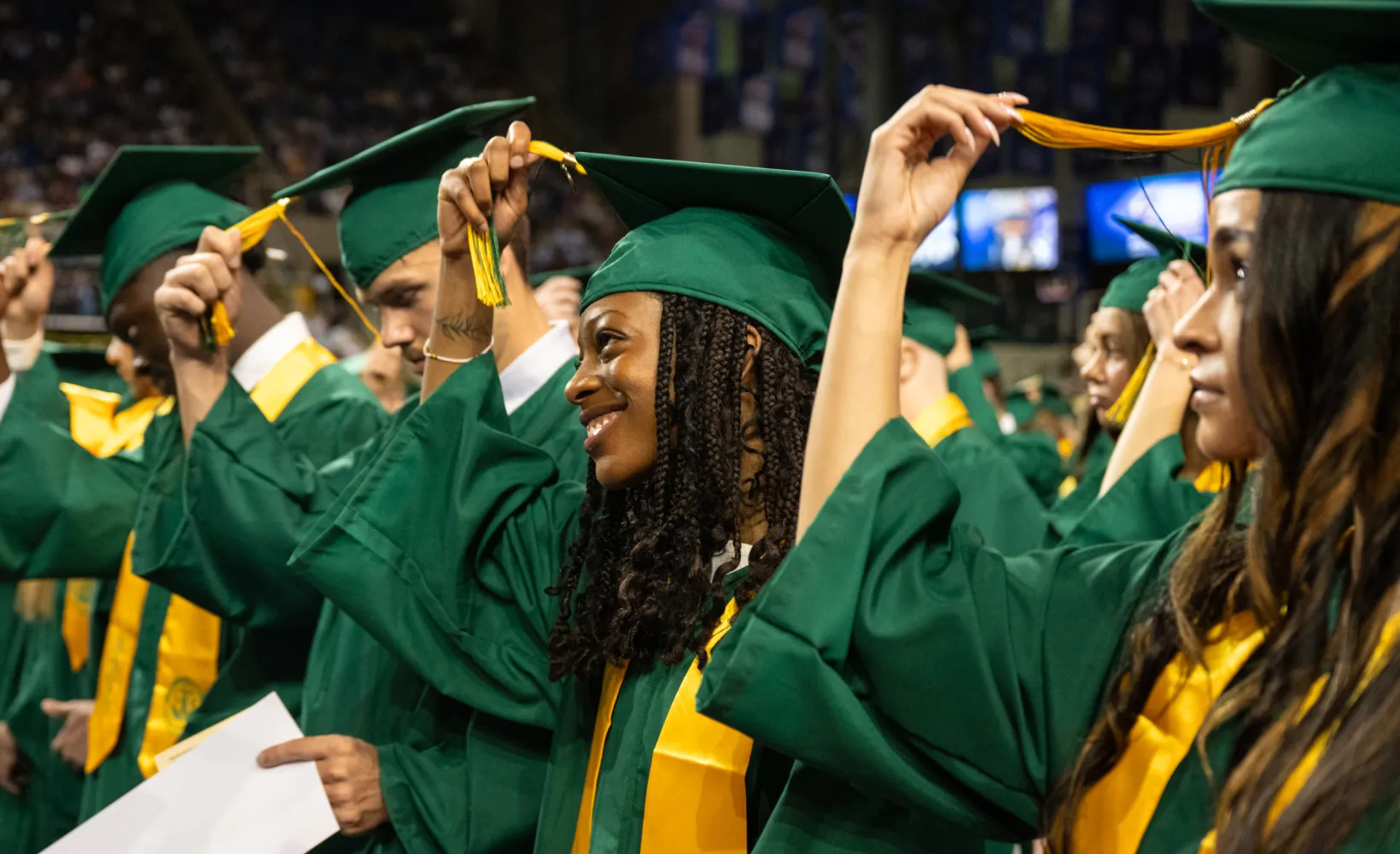 graduates move their tassles to the opposite side during commencement ceremony