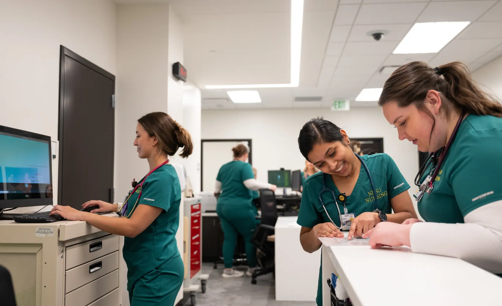 nursing students discuss charts as part of their class work