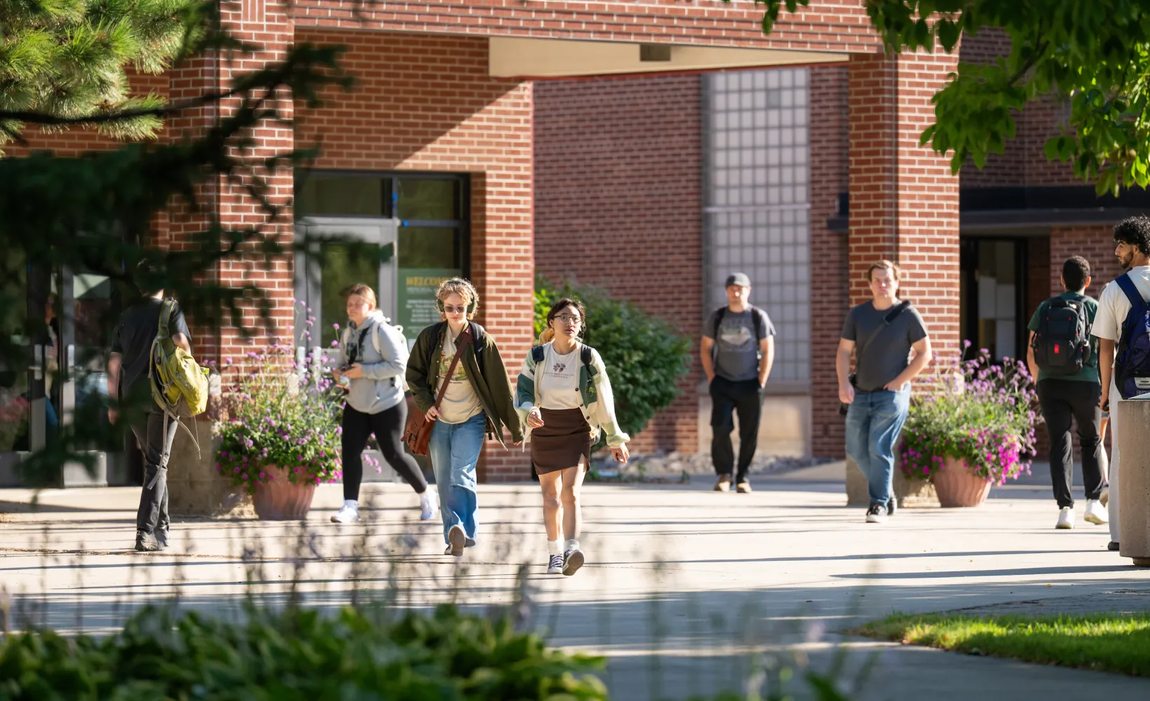 Students walking past south entrance of Memorial Union on sunny day.