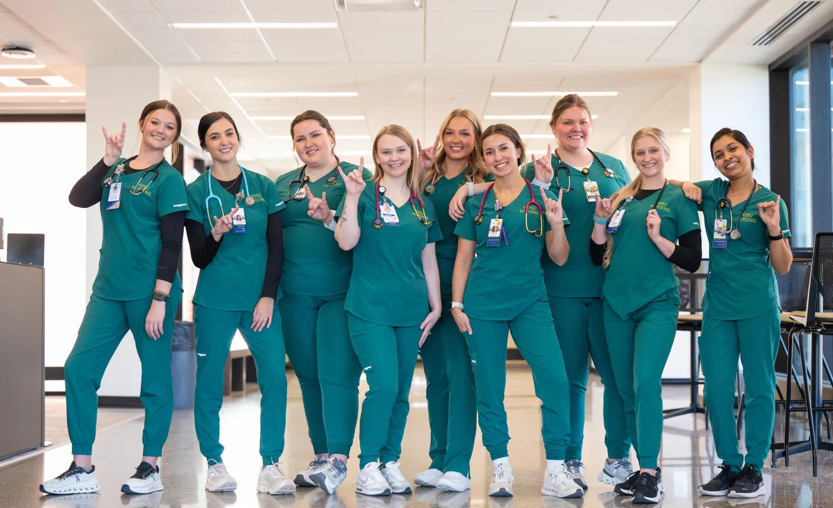 Group of nursing students in green scrubs