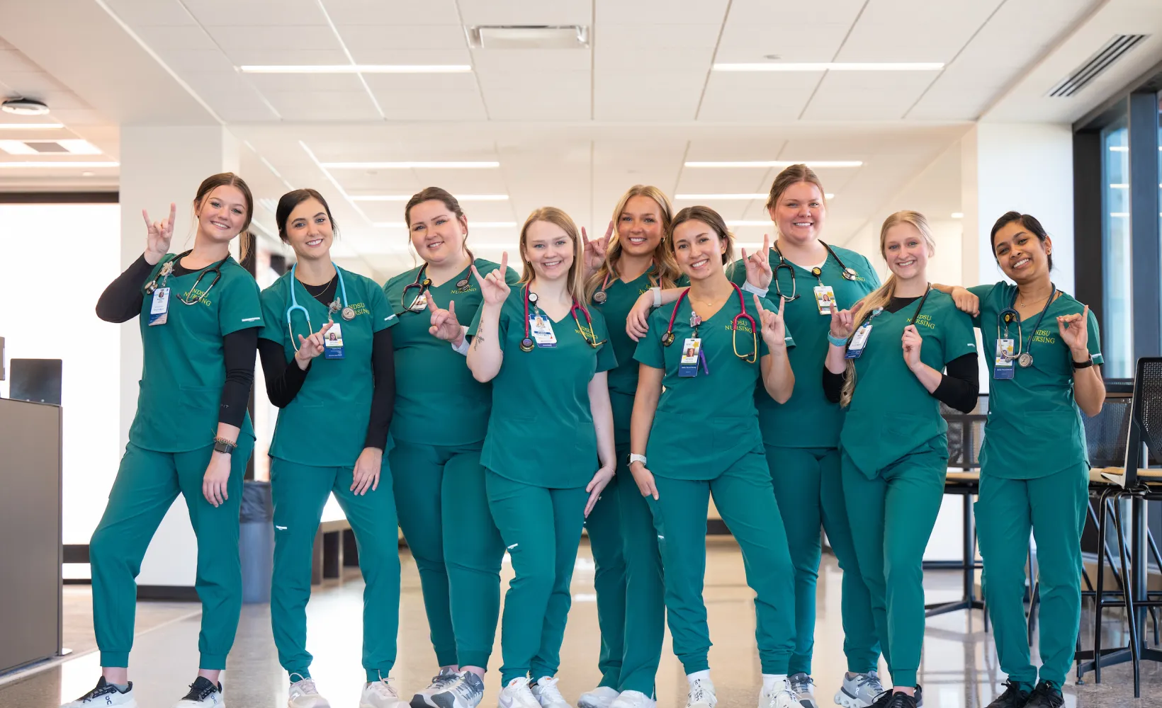 Group of nursing students in green scrubs