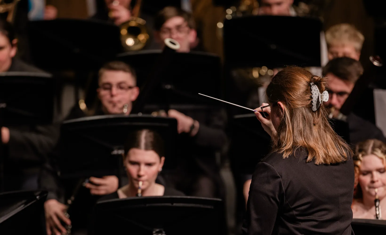 A female NDSU graduate student conducting the University Band