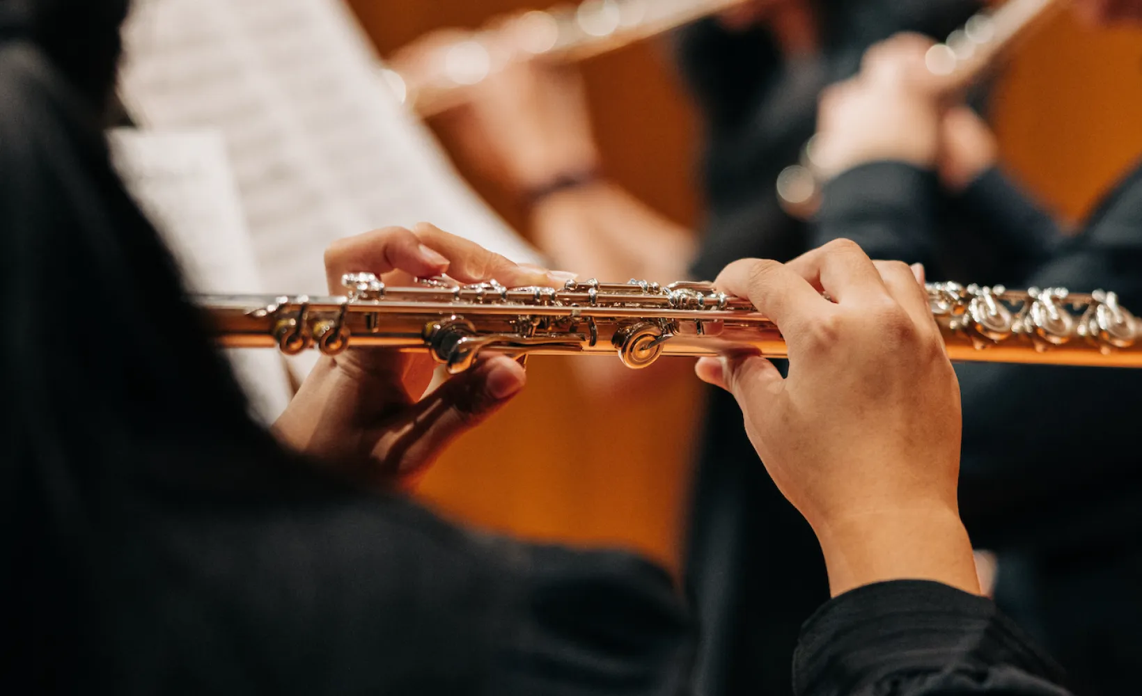 An up close photo of a woman playing a flute