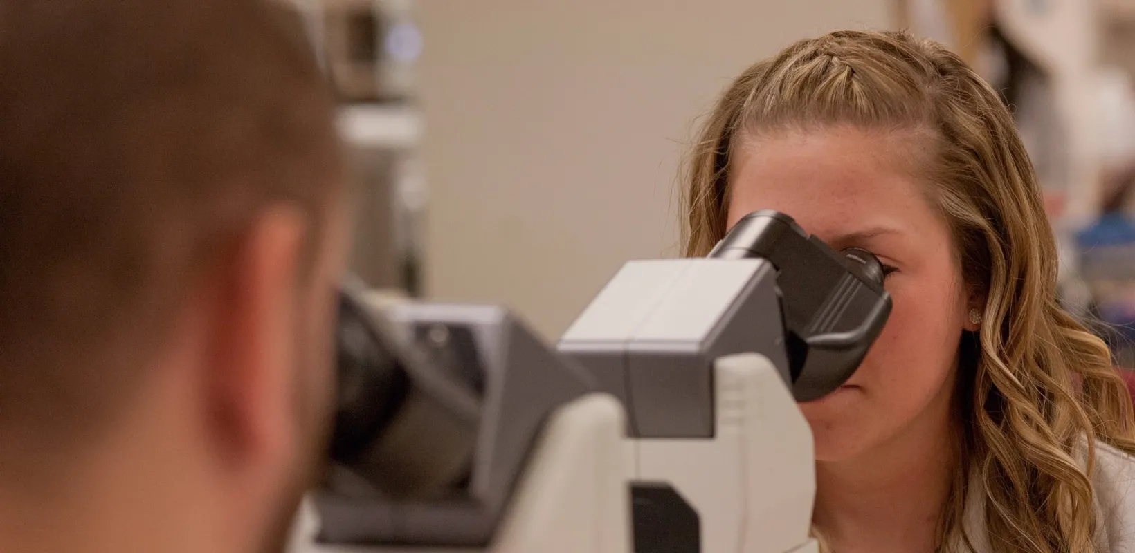 two student using microscopes