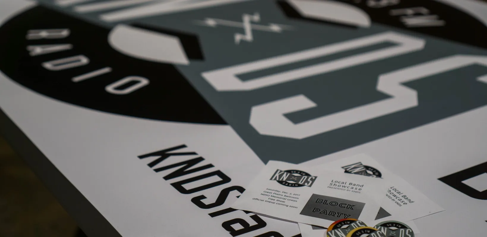 KNDS radio marketing materials: banner, pins and business cards.