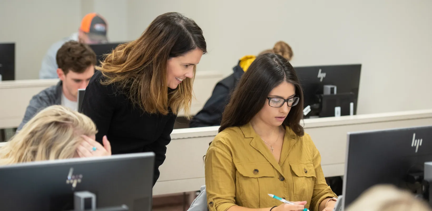 Faculty working with a student at her computer.