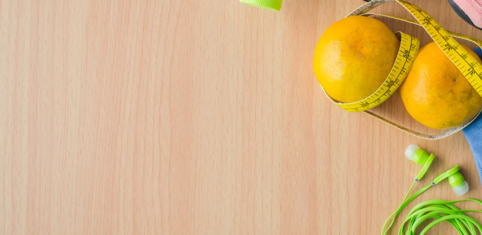 Running shoes, measuring tape, gym shorts and earbuds, oranges 