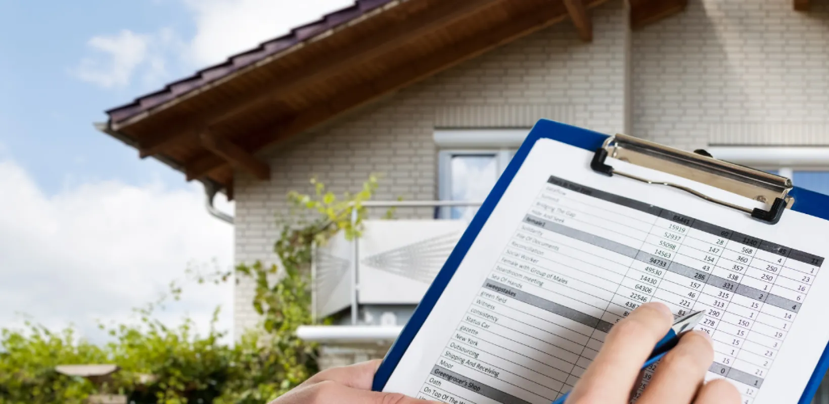 Person looking at a house with a home inspection checklist on a clipboard 