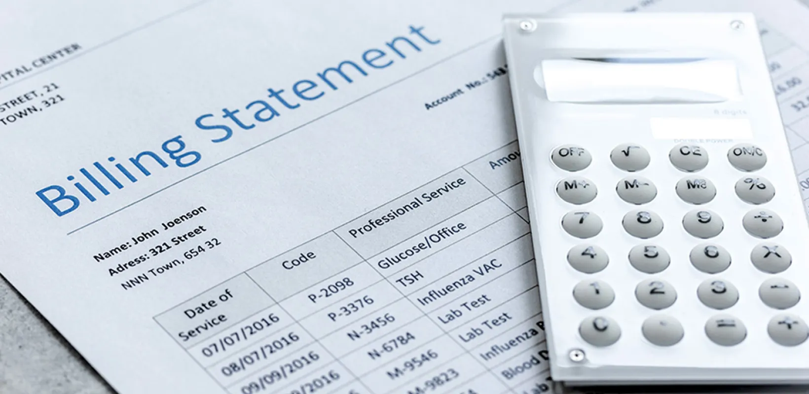 Medical Billing statement with a calculator laying on top of the paper