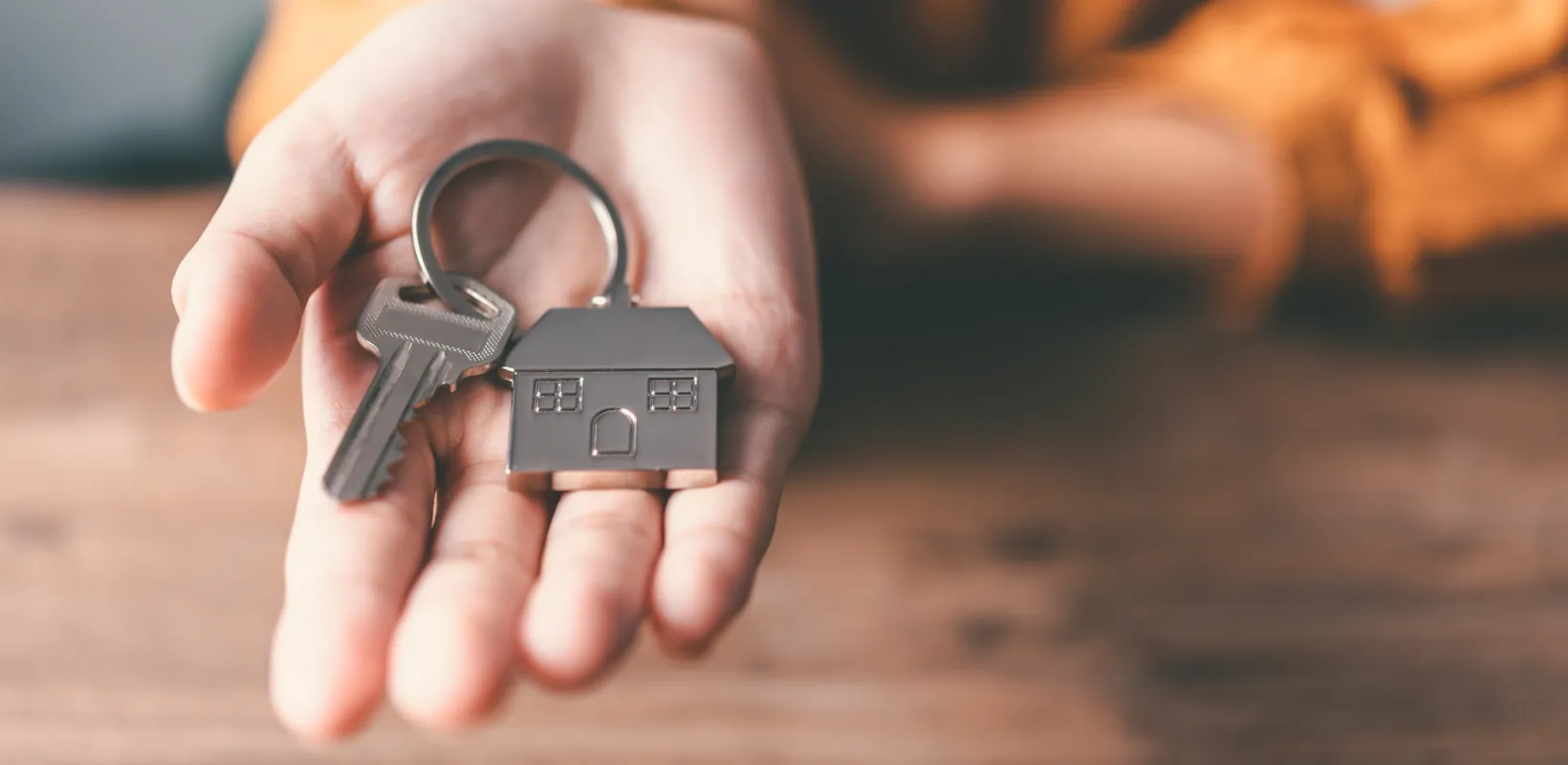 A key on a house keychain laying on an open palm.