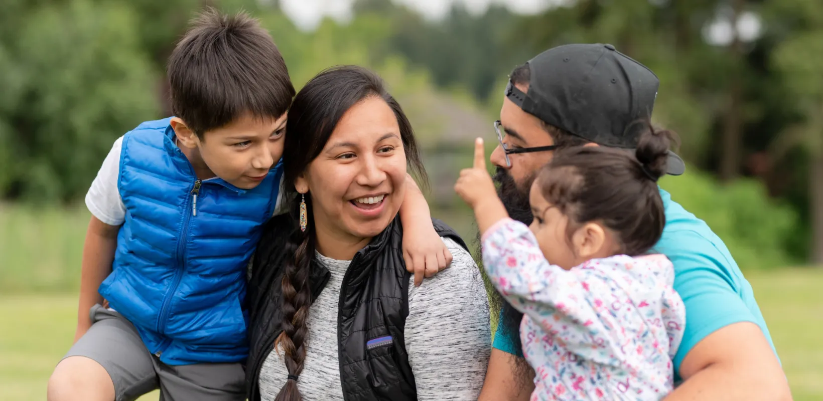 Two parents and two children sitting together outside visiting.