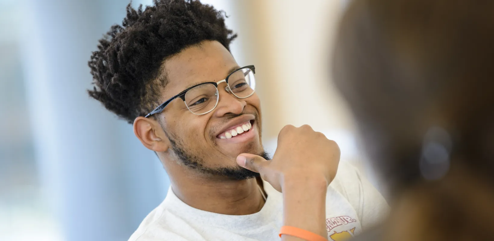 Student smiling while sitting in class. 