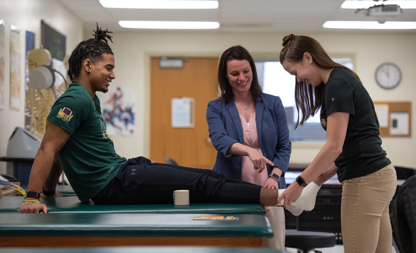 students practice athletic training concepts while a faculty member watches