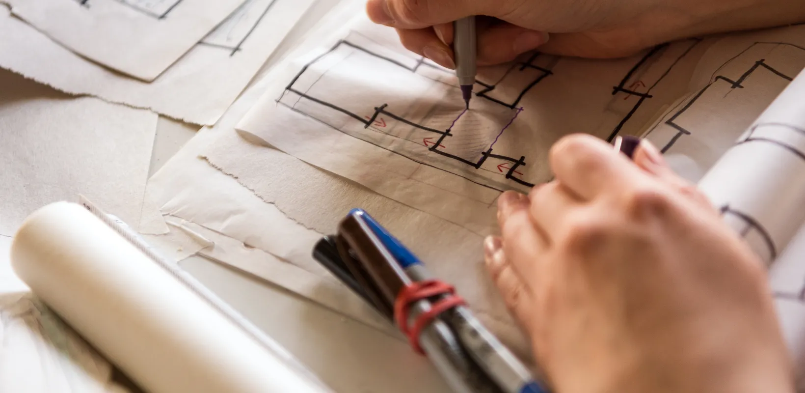 Student drawing on paper with pen.