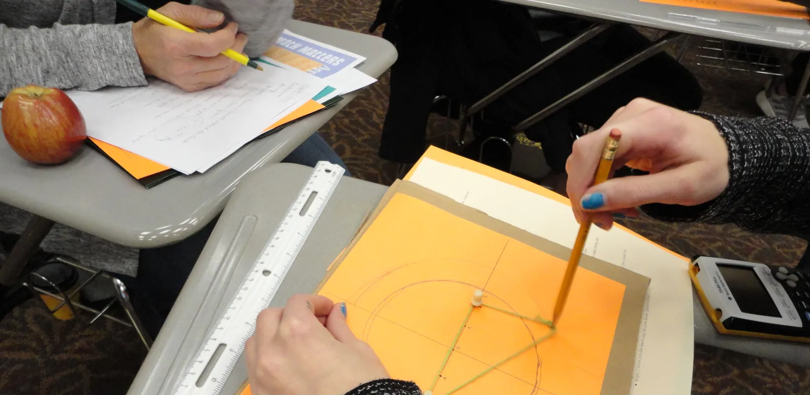 Student working on a math problem with pencil and paper. 