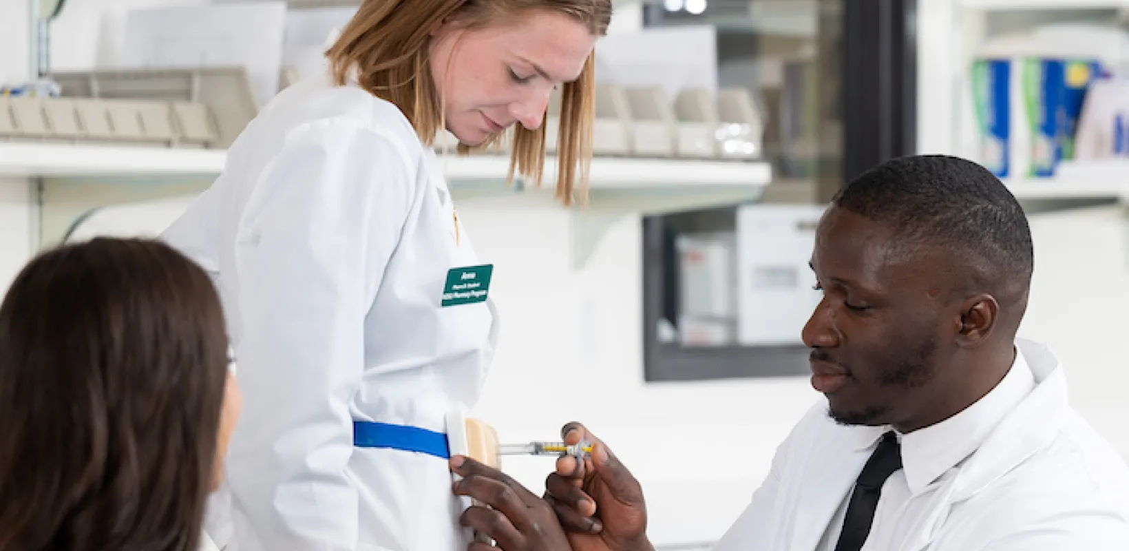 faculty working with student in a pharmacy