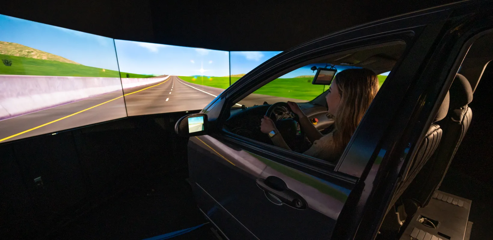 Student sitting in the driver seat of the driving simulator.