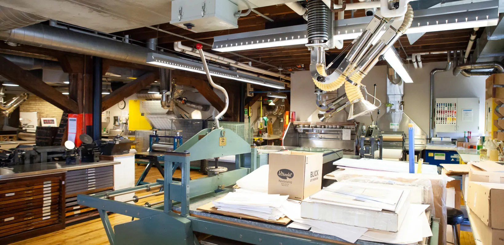 Tables, chairs, supplies and equipment in printmaking studio.