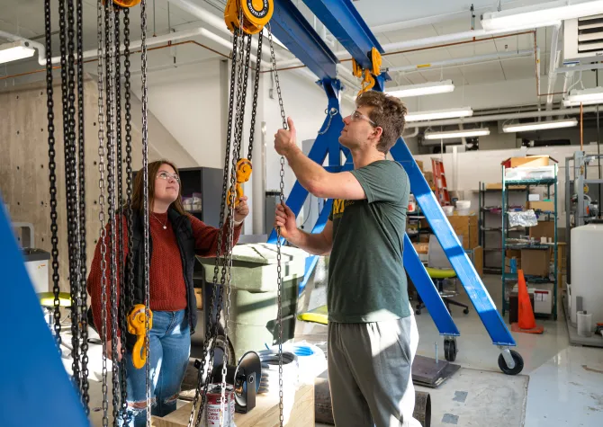 students working in a shop with a hoist