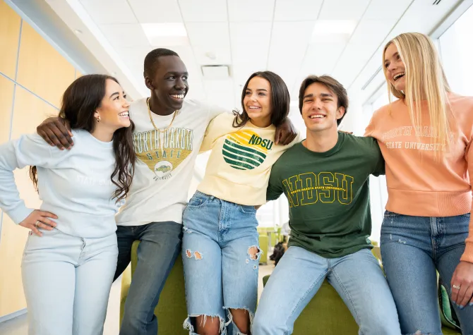 five students talking and laughing while wearing NDSU sweatshirts