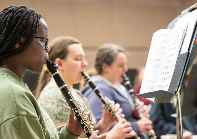 Students playing their clarinets during band practice.