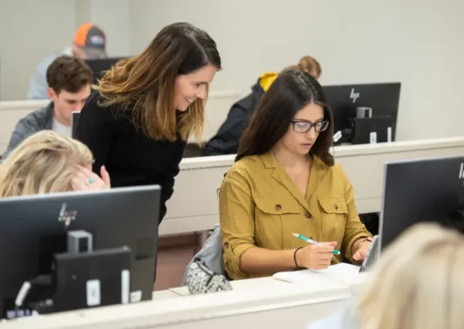 Agriculture communications student working with teacher in classroom