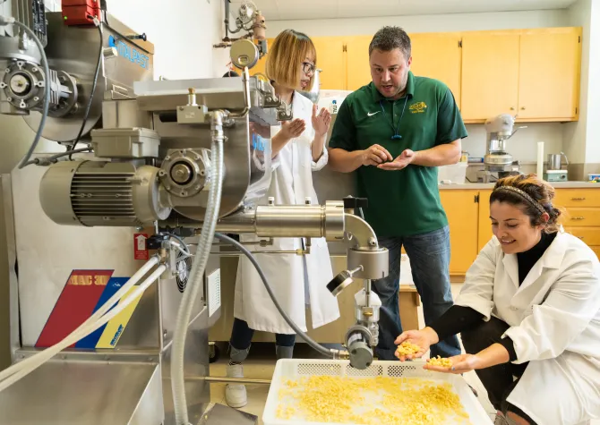 Food science students making pasta with pasta machine