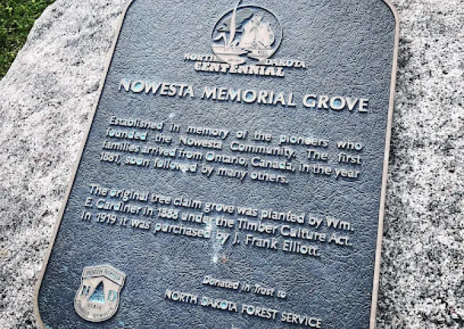 A sign that reads "Nowesta Memorial Grove" on a stone