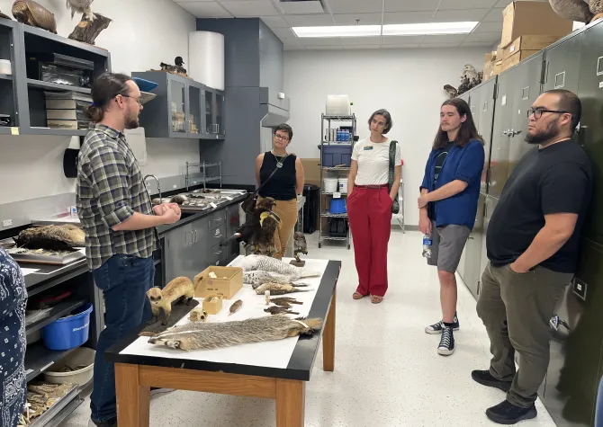People stand in a half cirlce talking in a lab